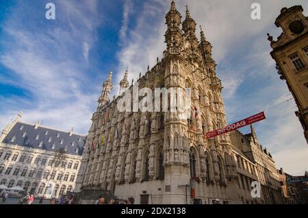 Leuven, Belgium, August 2019. The town hall square is dominated by the eye-catching palace decorated with numerous statues and colored flags. Beautifu Stock Photo