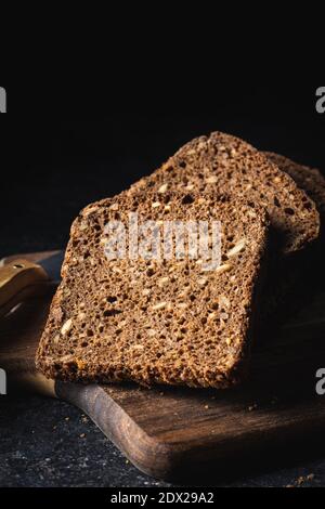 Dieting cereal bread with sunflower seeds on black table. Stock Photo