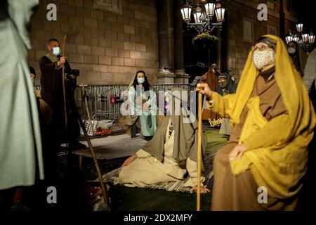 People dressed in biblical costumes and wearing face masks  perform a Live Nativity Scene  in Barcelona downtown. Stock Photo
