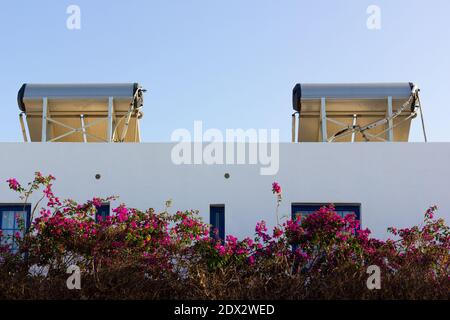 Solar panels on roof of white apartment complex. Photo voltaic modules installed on top of house building. Sunlight source of energy concept Stock Photo