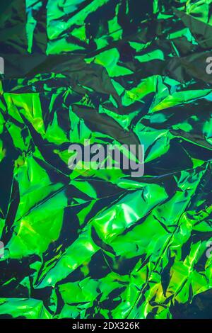 Green crumpled textured holographic trendy dark background Stock Photo