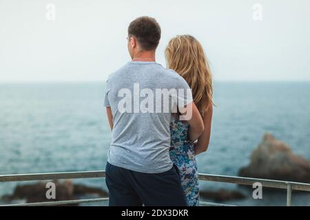 Young man hugging his girlfriend with a sea view Stock Photo