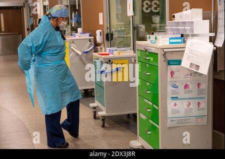 Roseville, California, USA. 22nd Dec, 2020. Registered Nurse Allison Shiftar puts on gown as she gets ready to go into one of the triage rooms to care for a COVID-19 positive patient in the emergency department at Sutter Roseville Medical Center on Tuesday, Dec. 22, 2020. Credit: Renée C. Byer/ZUMA Wire/Alamy Live News Stock Photo