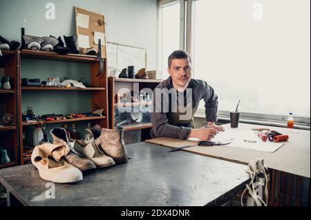 Hereditary tanner will be conducting a master class on making shoes from the skin, making a pattern on paper in his studio. Stock Photo