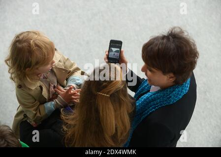 Najat Valaud Belkacem shows French Digital Technology Junior Minister Axelle Lemaire a picture on her smartphone as they attend the annual Bastille Day military parade at Place de la Concorde, in Paris, France on July 14, 2014. Photo by Ammar Abd Rabbo/ABACAPRESS.COM Stock Photo