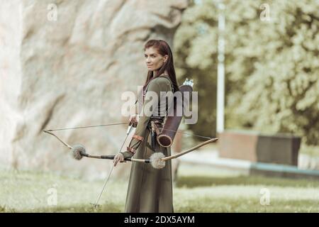 Archery woman with bow shooting on the forest Stock Photo