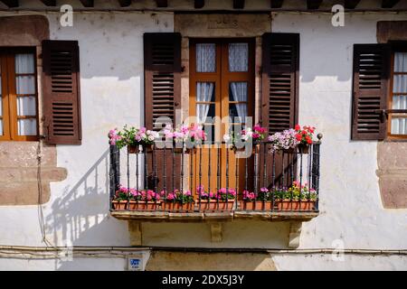 Typical spanish Basque upper floor door with balcony decorated with flowers Stock Photo