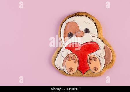 Gingerbread shaped as sloth with big red heart in his arms, ginger cookies,  Stock Photo