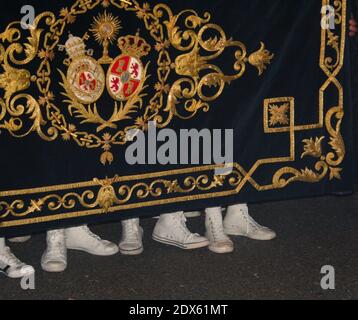 Row of baseball boot clad feet of the costaleros under an Easter procession float in Seville Andalusia Spain Stock Photo