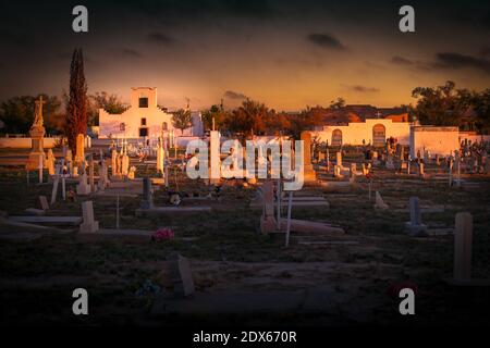 The sun sets at the grave yard near the Socorro Mission, built in 1840, near El Paso, Texas. Stock Photo