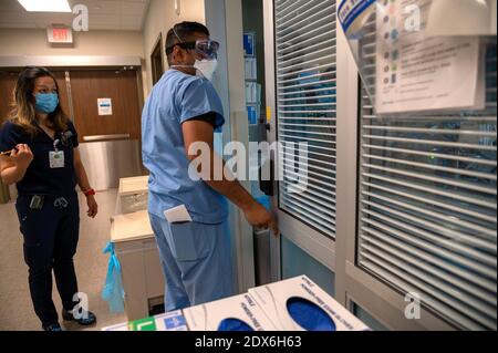 Roseville, California, USA. 22nd Dec, 2020. Physician Assistant William Murray, center, checks on a COVID-19 positive patient in ICU along side Registered Nurse Glenda Real at Sutter Roseville Medical Center on Tuesday, Dec. 22, 2020. Credit: Renée C. Byer/ZUMA Wire/Alamy Live News Stock Photo