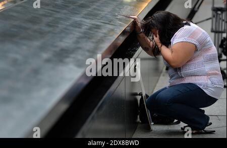 Janice Lynch, of Queens, New York, pauses at the inscription of her friend Patricia Massani's name at the North Pool during memorial observances on the 13th anniversary of the 9/11 terror attacks, at the site of the World Trade Center in New York City, NY, USA, 11 September 2014. Photo by Justin Lane/POOL/ABACAPRESS.COM