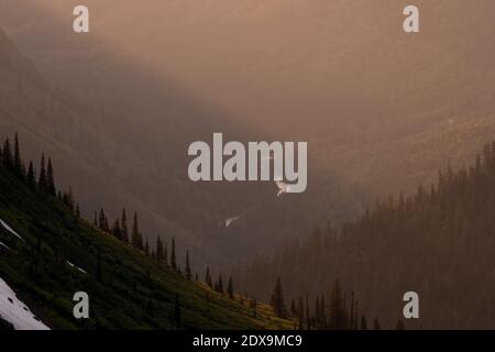 Mountain Sides and Sun Rays Criss Cross At Sunset from overlook on Going to the Sun road Stock Photo