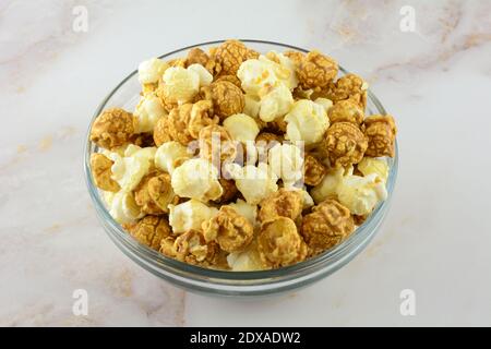 Caramel and cheddar popcorn on glass snack bowl on table Stock Photo
