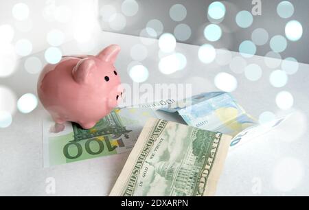 Piggy Bank Stands On Paper Euro And Us Dollar Bills, Light Bokeh Background, Like Dreams