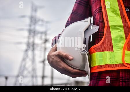 Close up hand holding white helmet hard hat Engineering concept Stock Photo