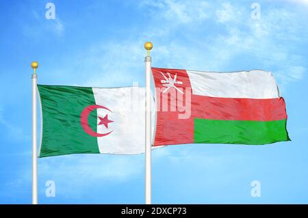Algeria and Oman two flags on flagpoles and blue sky Stock Photo