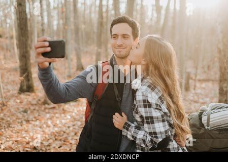 Young couple taking smart phone selfie during autumn hike Stock Photo