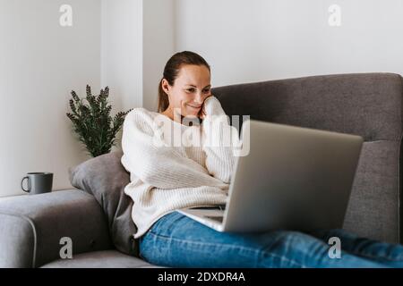 Caucasian woman watching video on laptop at home Stock Photo