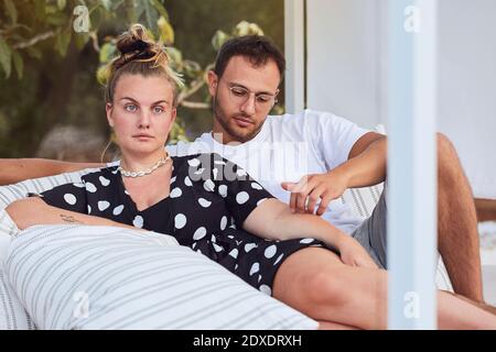 Affectionate young couple relaxing on sofa in back yard Stock Photo