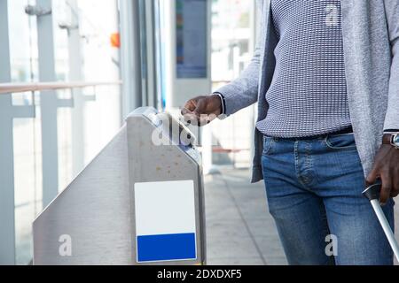 Businessman scanning ticket at gate of railroad station Stock Photo