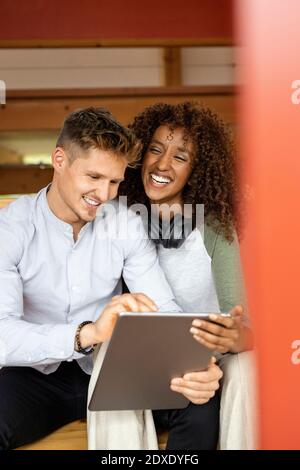 Smiling couple using digital tablet while sitting at home Stock Photo