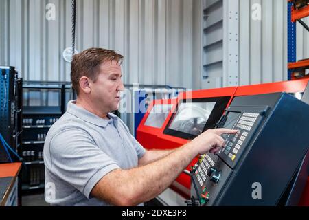 Industrial male manual worker operating control panel at industry Stock Photo