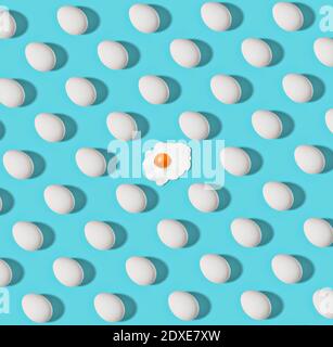 Pattern of white chicken eggs and single fried one Stock Photo