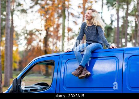 Happy woman on roof top of camper van at Cannock Chase Stock Photo