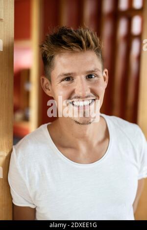 Young man smiling while standing at home Stock Photo