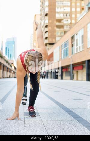 Athlete with prosthetic leg crouching for sports race on footpath Stock Photo