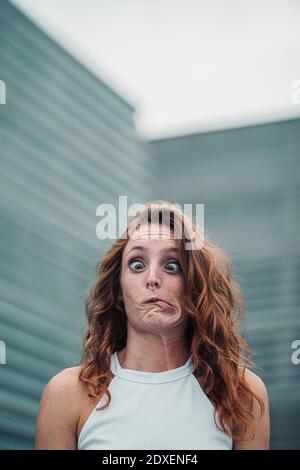 Woman showing weird facial expression while standing outdoors Stock Photo