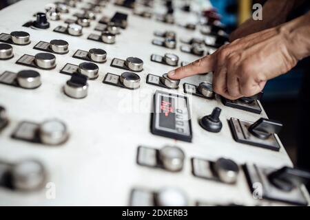 Man's hand operating control panel in factory Stock Photo