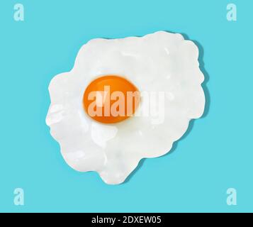 Fried egg against blue background Stock Photo