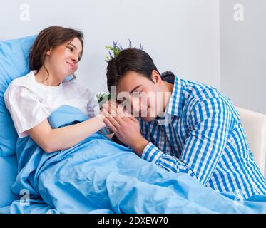 The caring loving husband visiting pregnant wife in hospital Stock Photo