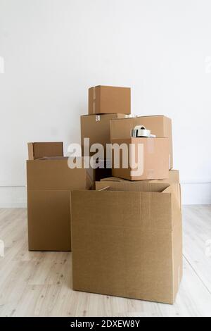 Stack of cardboard boxes against wall in empty room Stock Photo