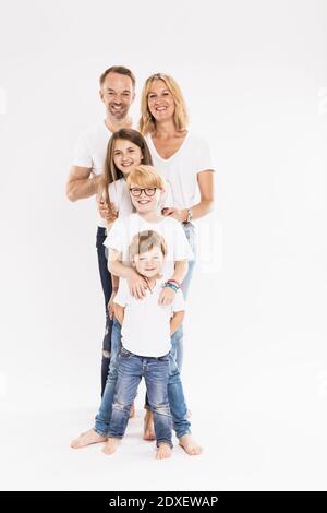 Happy family with children standing in row against white background Stock Photo