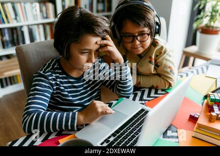 Male friends e-learning through laptop at home Stock Photo