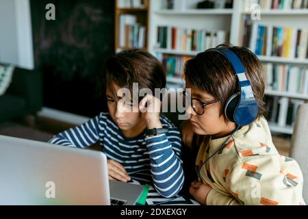 Boys attending homeschooling class through laptop Stock Photo