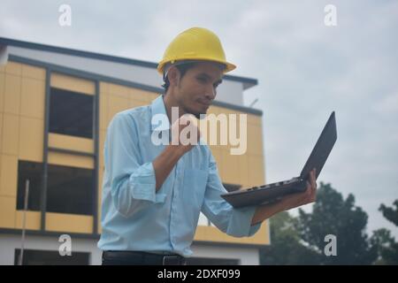 Engineering use computer notebook presentation at work place building estate construction background Stock Photo