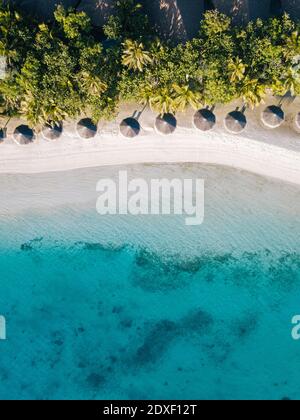 Maldives, Kaafu Atoll, Hudhuranfushi, Aerial view of row of huts along sandy coastal beach of Hudhuranfushi island Stock Photo