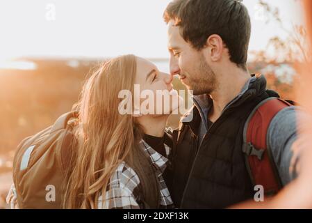 Portrait of young couple affectionately looking at each other during autumn hike Stock Photo