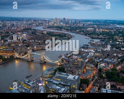 UK, England, London, Helicopter view of River Thames, Tower Bridge and surrounding buildings at dusk