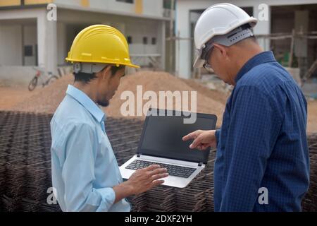 Two Engineering use computer notebook presentation at work place building estate construction background Stock Photo
