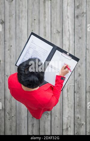 Female engineer drawing diagram while standing on wooden floor Stock Photo