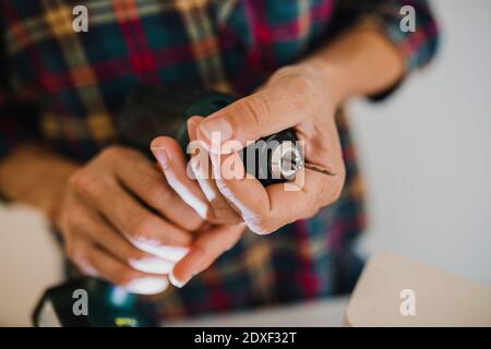 Close-up of woman holding chuck of electric drill while standing at home Stock Photo