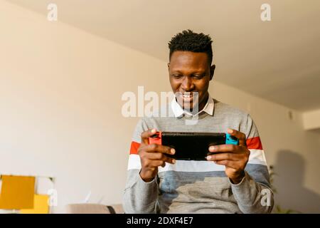 Male entrepreneur playing video game at home during break from work Stock Photo