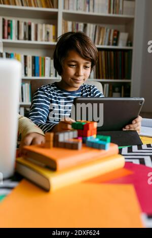 Smiling boy using digital tablet at table Stock Photo