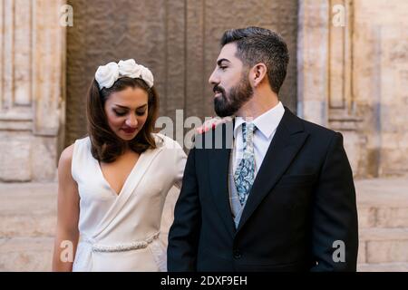 Newly married couple against church Stock Photo