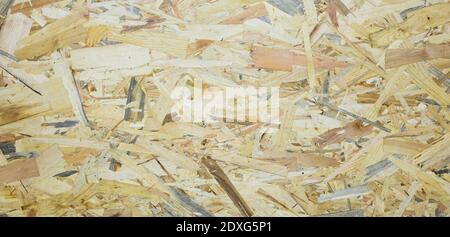 A Fiberboard. Compressed light brown wooden plywood texture. Close up surface of pressed wood-shaving plate. Old wooden board bagasse background. Pref Stock Photo